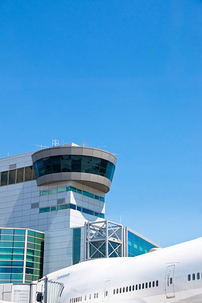istock Airplane in Front of Airport Tower 539850850