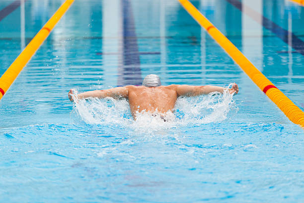 istock dynamic and fit swimmer in cap breathing performing the butterfly 539851472