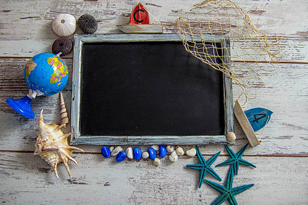 istock Blackboard with wooden frame and shells on the sand. 539853098
