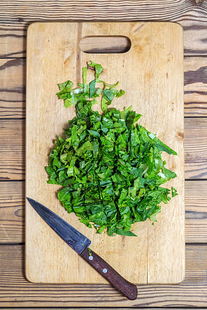 istock Chopped spinach, lettuce, parsley on cutting Board with  knife. 539853814