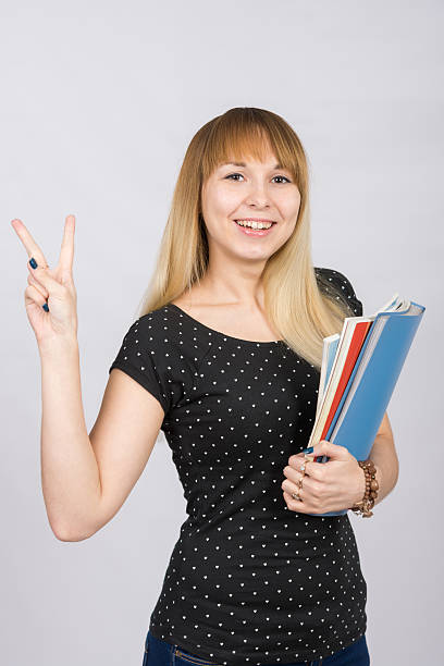 istock The joyful girl with a folder in his hands shows 539855576