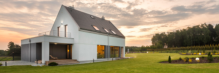 Panoramic photo of new style white villa with big backyard, outdoor view