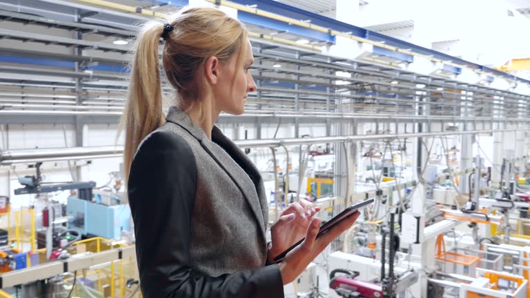 Businesswoman working on tablet in futuristic factory