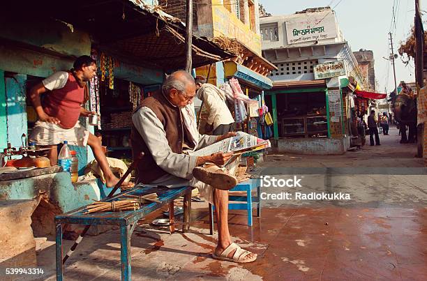 Senior Sitting Outdoor And Reading An Indian Newspaper Stock Photo - Download Image Now