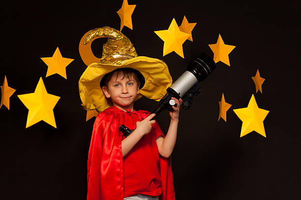 istock Boy in sky watcher costume with telescope 539943920