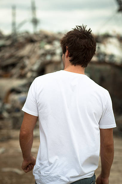 Vista posteriore di un giovane maschio all’aperto indossando t-shirt bianca - foto stock