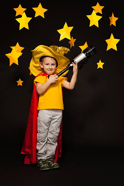 istock Kid boy playing sky watcher with a telescope 539944622