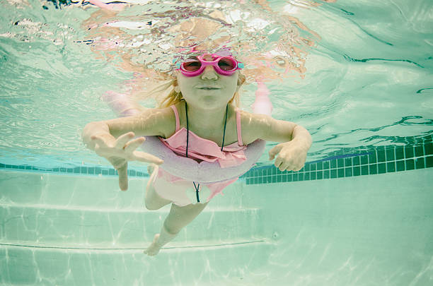 Portrait of a happy girl whit swimming googles in swimming pool