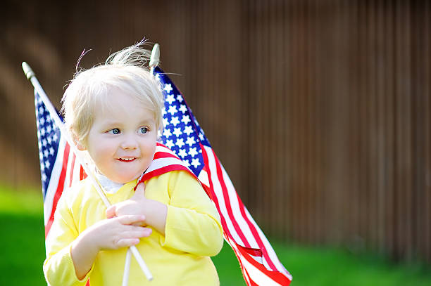 istock Cute toddler boy holding american flag 539945480