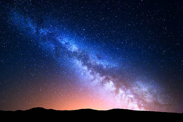 Night landscape with colorful Milky Way Night landscape with colorful Milky Way and yellow light at mountains. Starry sky with hills at summer. Beautiful Universe. Space background milky way stock pictures, royalty-free photos & images