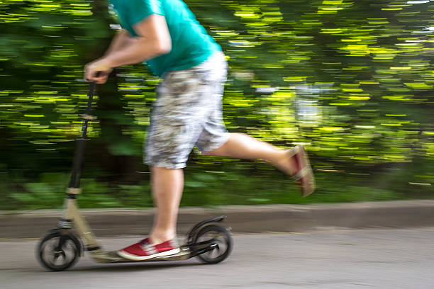 istock man rides a scooter at speed down  road, blurred background 539946412