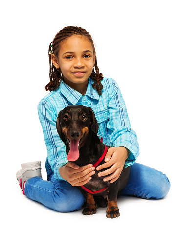 African American girl hugging friendly small dachshund isolated on white 