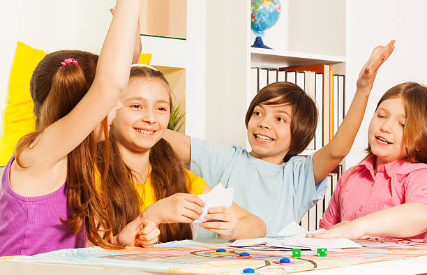 istock Kids giving hive five sitting at the gaming table 539948950
