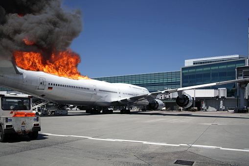 Fake composition of huge airliner engulfed in flames at airport gate.