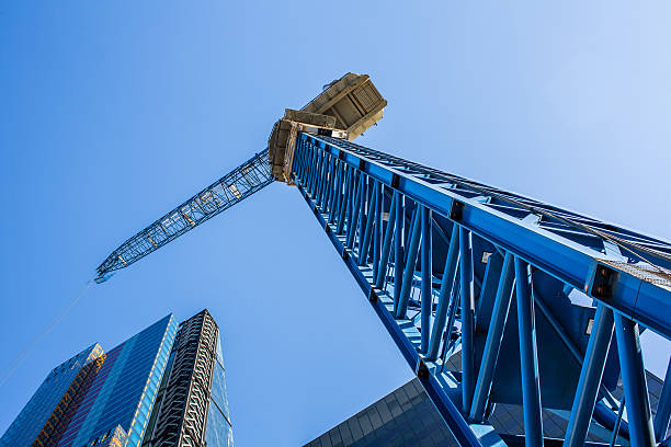 konstrukcja dźwigu nad nowoczesnym budynkiem - blue construction construction site crane zdjęcia i obrazy z banku zdjęć