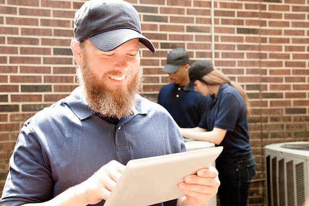 istock Air conditioner repairmen work on home unit. Blue collar workers. 539951630
