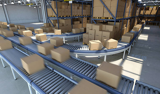 Boxes moving on conveyor belt inside warehouse, ready for delivery Boxes and packed goods moving on conveyor belt inside a large distribution warehouse building, with plenty of cardboard boxes and goods stacked on pallets on the background. Industrial system for storage, distribution and delivery services. Blurred motion effect on foreground packages. Digitally generated image. big cardboard box stock pictures, royalty-free photos & images