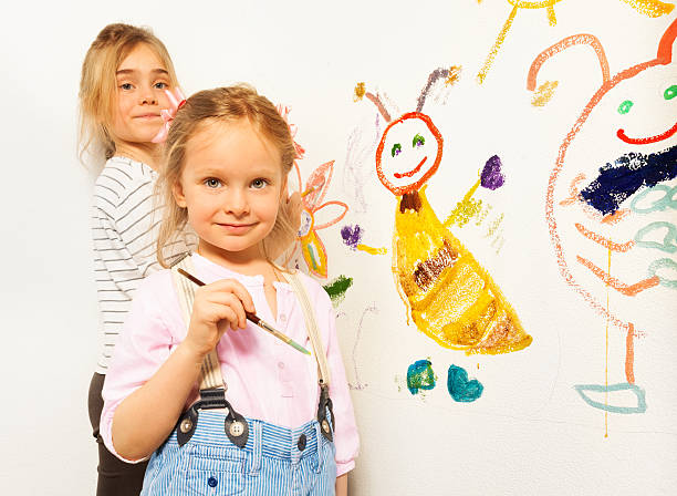 istock Cute little girls with brushes drawing funny bugs 539952884