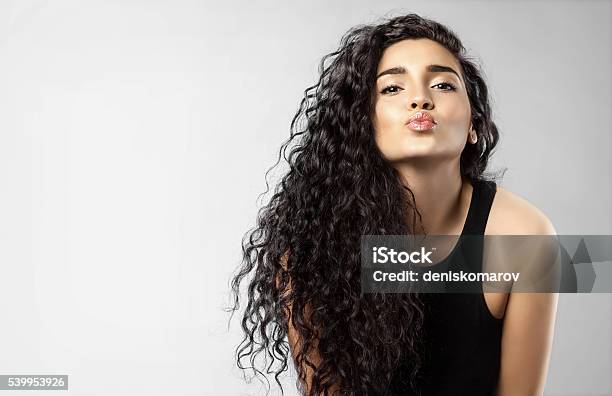 Foto de Mulher Real Com Cabelo Preto Bonito Dá Um Beijo e mais fotos de stock de Cabelo Encaracolado - Cabelo Encaracolado, Mulheres, Modelo profissional