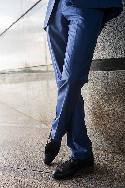 istock Legs of unrecognizable businessman on a sidewalk. 539954376