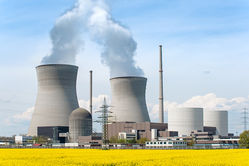 Nuclear power Energy concept - Nuclear power plant with yellow field and big blue clouds. Nuclear power plant in Germany