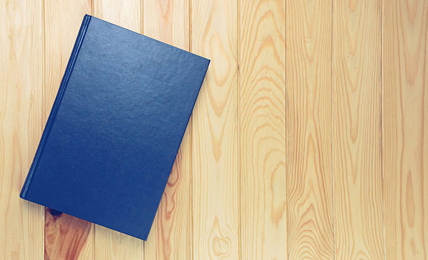 istock dark blue book on brown wooden table 539958548