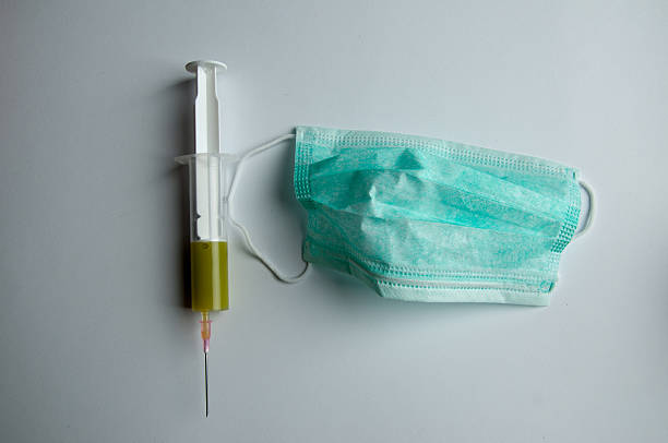 istock syringe and mask on white background 539959020