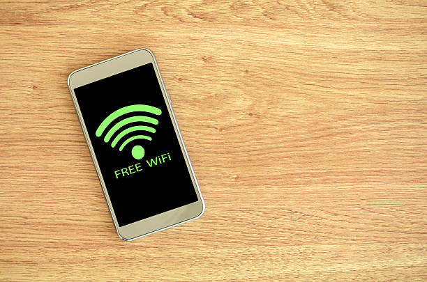 istock Smart phone on wood background with free Wifi sign. 539959988