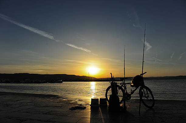 sunset fishing rod bike sunset fishing rod bike bogaz stock pictures, royalty-free photos & images