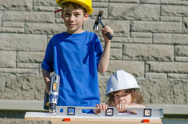 istock Little boy and girl playing with big tools outside 539960424