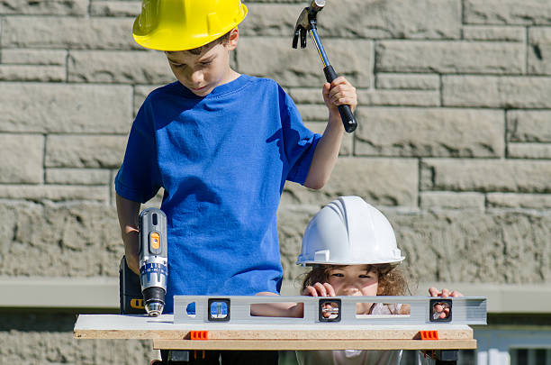 istock Little boy and girl playing with big tools outside 539960462