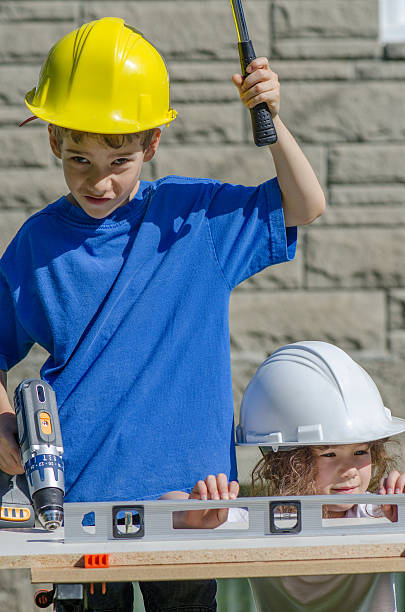 istock Little boy and girl playing with big tools outside 539960536