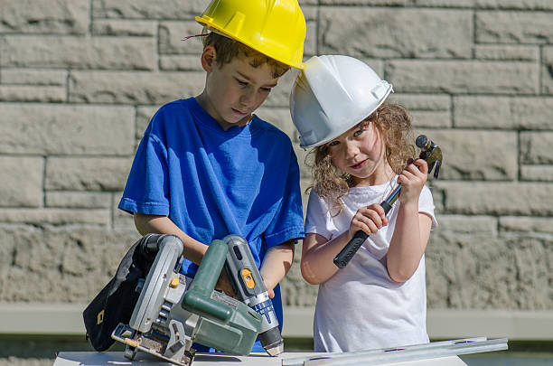 istock Little boy and girl playing with big tools outside 539960600