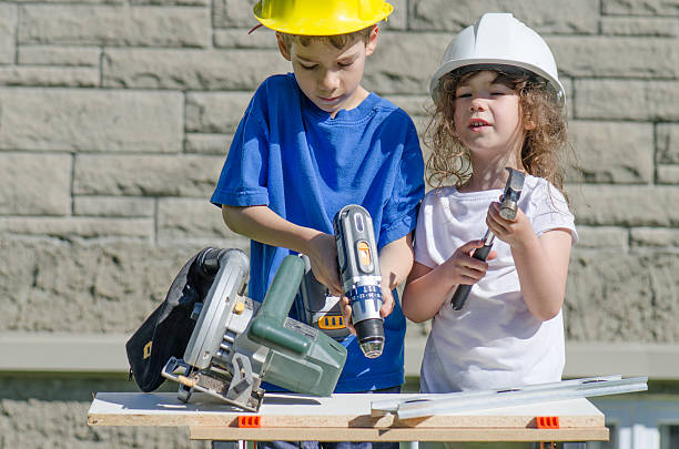 istock Little boy and girl playing with big tools outside 539960702