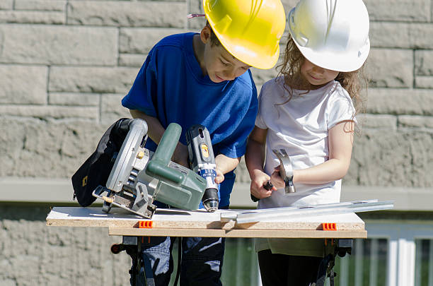 istock Little boy and girl playing with big tools outside 539960720