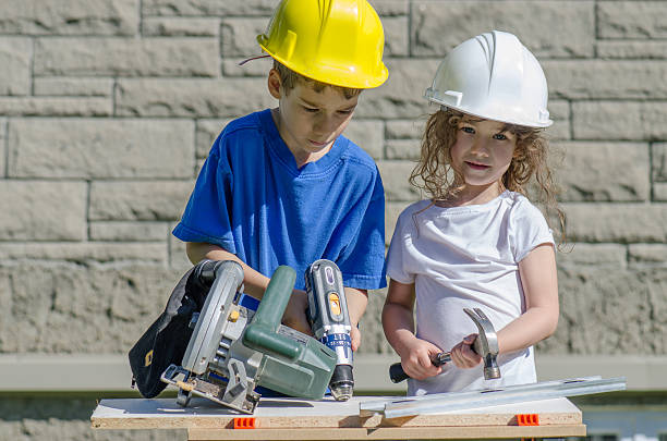 istock Little boy and girl playing with big tools outside 539960770