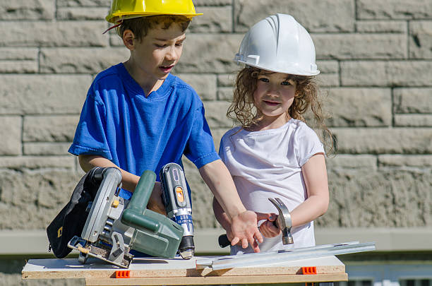 istock Little boy and girl playing with big tools outside 539960798