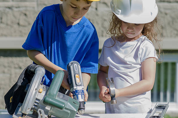 istock Little boy and girl playing with big tools outside 539960826