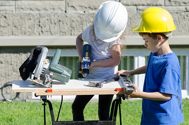istock Little boy and girl playing with big tools outside 539960848