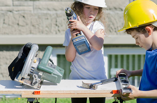 istock Little boy and girl playing with big tools outside 539960892