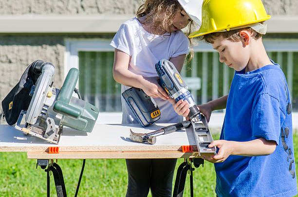 istock Little boy and girl playing with big tools outside 539960922