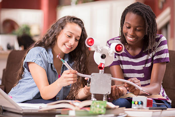 Education.  Teenage girls studying science, engineering at home. Homework. NOTE:  Robot created by photographer.  high school high school student science multi ethnic group stock pictures, royalty-free photos & images