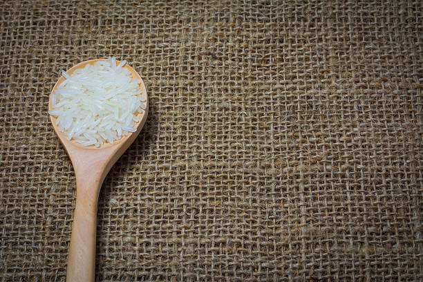 istock Rice with wooden Spoon on sack background 539965604