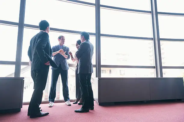 This is a horizontal, color photograph of a tech startup entrepreneur speaking to an international group of business people to discuss the growth of his company. Photographed with a Nikon D800 DSLR camera in Kyoto, Japan.