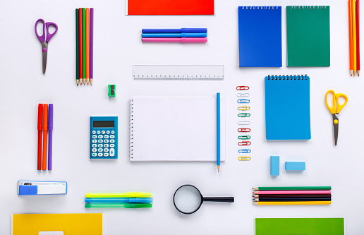 School supplies with a notebook with blank pages for your text on a white background. Flat lay, top view