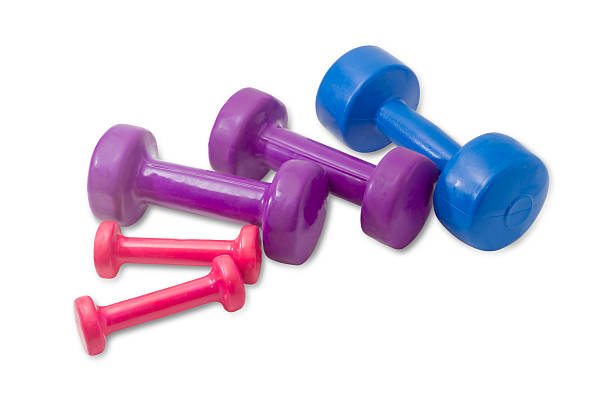 istock Several dumbbell different colors, weight and sizes on light bac 539972368