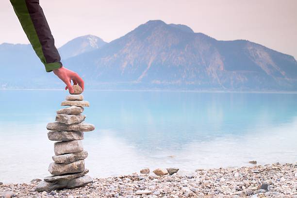 istock Man built pyramid from pebbles. Balanced stones pyramide memories 539972948