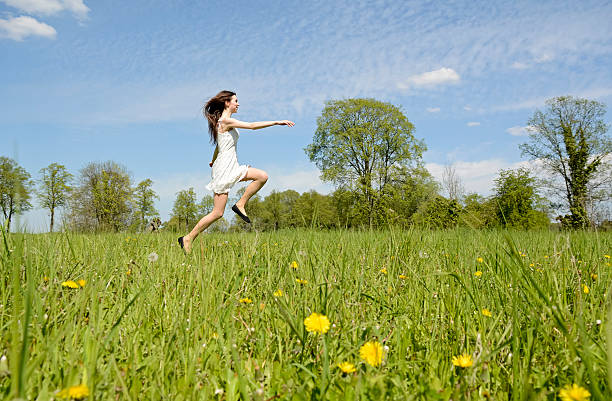 istock woman jumping on meadow 539974634