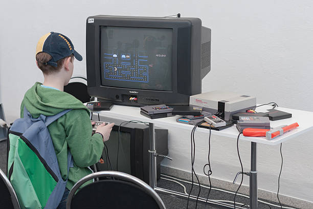 Boy plays gaming console with television at Animefest stock photo