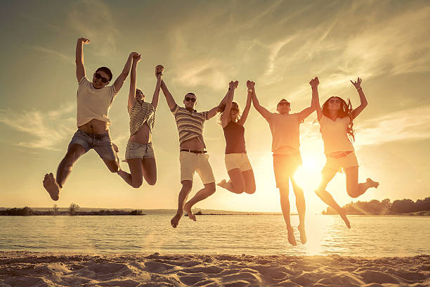 istock Friends jumping on the beach under sunset sunlight. 539978392